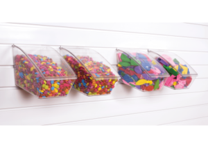 Crystal Clearboxes with lids containing a variety of candy and balloons on Slatwall